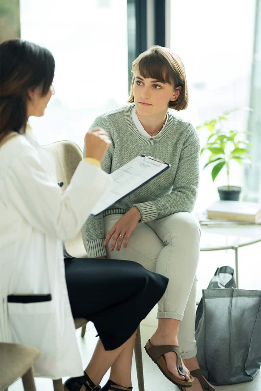 Shot of a doctor having a discussion with her patient in the waiting room of a clinic