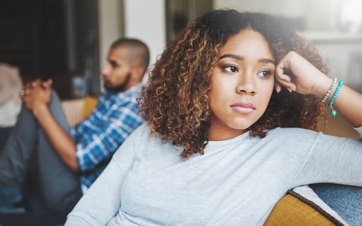 How to Break up with your Current Managed Services Provider: Shot of a young woman looking upset after a fight with her husband in the background