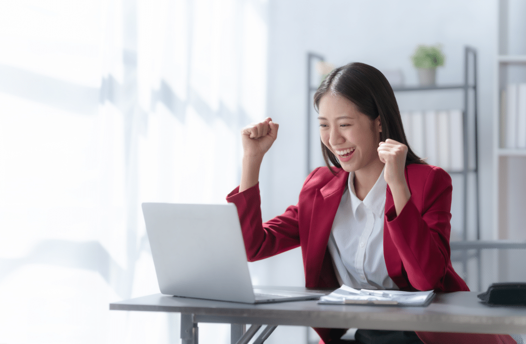 Woman at computer after successfully completing a task